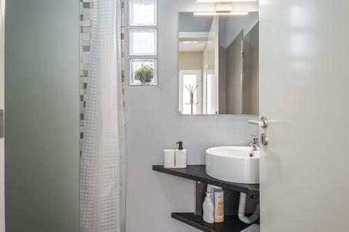 y baño con lavabo y espejo. en The Blue House en Funchal