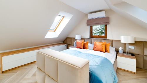 a attic bedroom with a bed and a window at Komfortowy Apartament LOTOS z sauną i widokiem na Śnieżkę in Karpacz