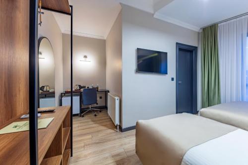 um quarto de hotel com uma cama e uma secretária em Lenora Airport Hotel em Arnavutköy