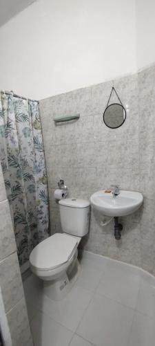 a bathroom with a toilet and a sink at Hotel Tunjo de oro Neiva in Neiva