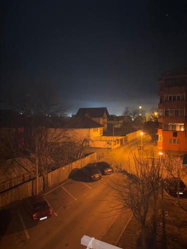 uma vista para uma rua à noite com carros estacionados em Strada Dacia nr 2 em Târgu Jiu