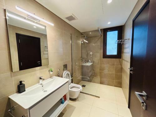 a bathroom with a sink and a toilet and a mirror at 1-Bedroom in Forest Island & Oceanside View in Salalah