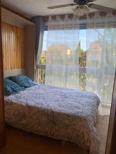 - une chambre avec un lit en face d'une fenêtre dans l'établissement St Aygulf Grand studio 400m de la plage, à Fréjus