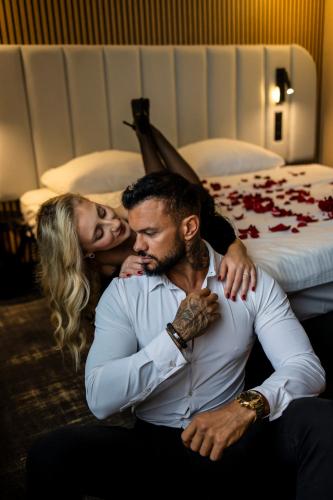 a man and a woman laying on a bed at Artis Loft Hotel in Radziejowice