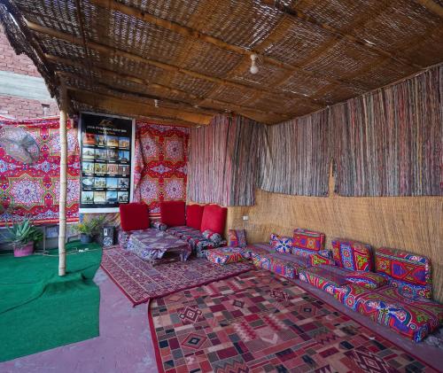 uma sala de estar com cadeiras vermelhas e um sofá em 2 Jana Pyramids view inn no Cairo