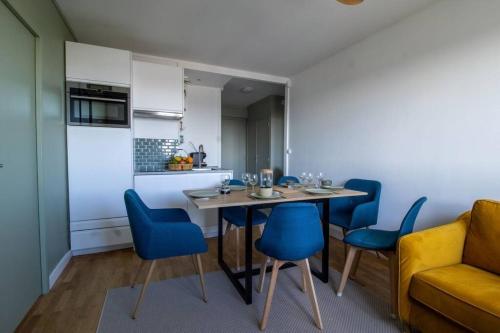 een eetkamer met een tafel en blauwe stoelen bij Renovated 2-Bed Apartment 2 min from Lyon in Oullins