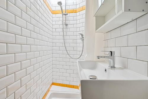 une salle de bain blanche avec un lavabo et une douche dans l'établissement Le Cœur Sacré - 4 personnes Montmartre - Wifi, à Paris