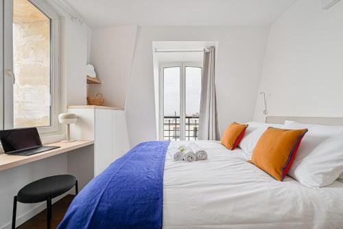 - une chambre avec un lit, un bureau et un ordinateur portable dans l'établissement Le Cœur Sacré - 4 personnes Montmartre - Wifi, à Paris