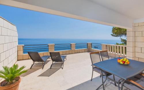 a balcony with a table and chairs and the ocean at Big Blue Apartments in Dubrovnik