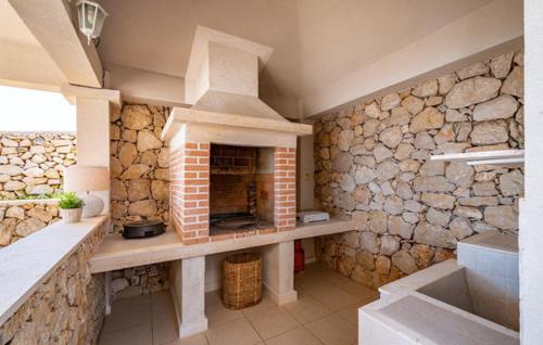 a kitchen with a stone wall with a fireplace at Villa Toma I in Novalja