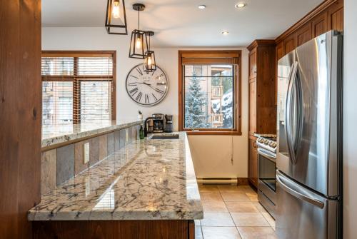 a kitchen with a large clock on the wall at Tremblant Prestige - Altitude 170-5 in Mont-Tremblant
