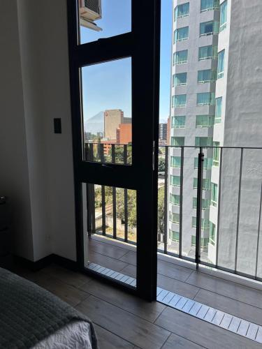 a room with a window with a view of a city at EÓN 9 - Moderno, vista volcán, aire acondicionado in Guatemala