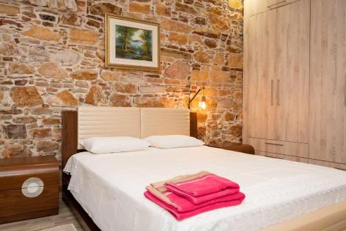 Un dormitorio con una cama con toallas rojas. en ΠΕΤΡΙΝΟ ΣΠΙΤΙ ΣΤΟΝ ΚΑΜΠΟ ΧΙΟΥ, en Chios