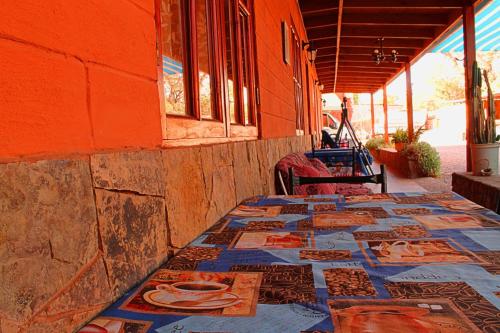 a table with mosaics on it next to a building at La Casa del Sol Naciente in San Pedro de Atacama