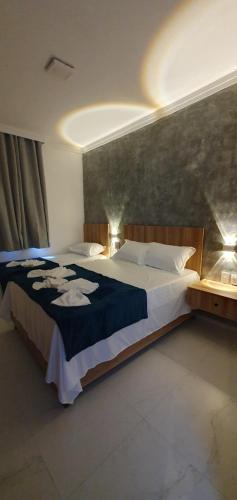 a bedroom with a large bed with a blue blanket at Hotel Da Orla in Aracaju