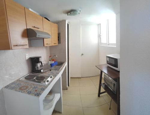 a small kitchen with a stove and a counter top at Departamento con vista al mar, albercas y juegos in Acapulco