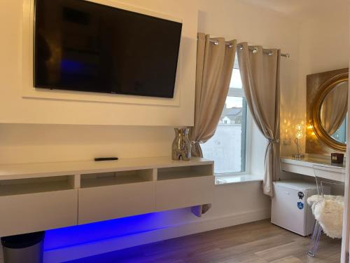 a living room with a flat screen tv on a wall at Vibrant Apartments Close to City Centre in Cardiff