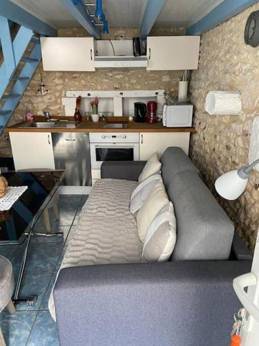 une petite chambre avec un canapé dans une cuisine dans l'établissement Location Mortagne -Sur Gironde, à Mortagne-sur-Gironde