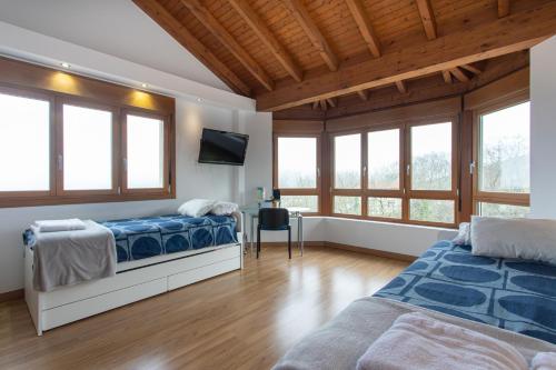 a bedroom with two beds and a flat screen tv at Apartamentos Cangas Relax En Grupo in Cangas de Onís