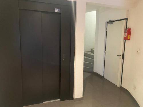 a black door in a hallway with a staircase at Petit cocon proche de Stanislas in Nancy