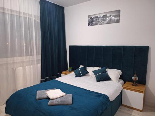 um quarto com uma cama grande e uma cabeceira azul em Studio - Cozy Home Slatina em Slatina
