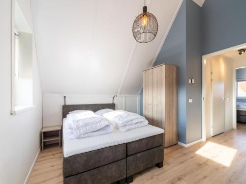 1 dormitorio con 1 cama con sábanas blancas en Modern holiday home in Scherpenisse with garden, en Scherpenisse