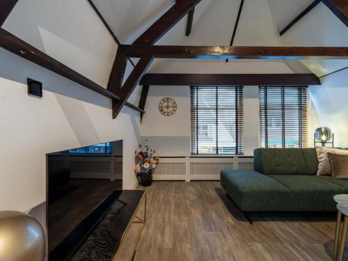 ein Wohnzimmer mit einer grünen Couch und einem Kamin in der Unterkunft Beautiful apartment on the first floor Abcoude in Abcoude