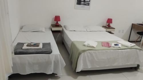 two beds in a hotel room with towels on them at Loft LISBOA para Casais, em Iguaba Grande, 3 Pessoas, 150 metros da praia in Iguaba Grande