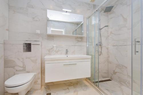 a bathroom with a toilet and a glass shower at Big Blue Apartments in Dubrovnik