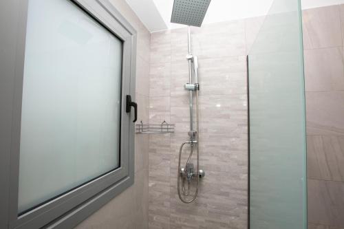 a bathroom with a shower with a glass door at SoL Apt Faliraki in Faliraki