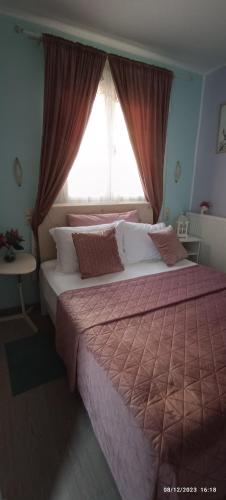 1 dormitorio con 2 camas y ventana en Marilidia House, en Kastéllion
