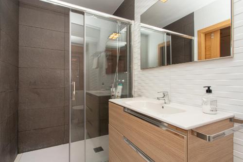 a bathroom with a sink and a shower at La Plaza de Cangas Apartamento Turistico in Cangas de Onís