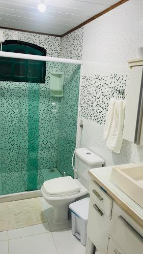 a bathroom with a toilet and a glass shower at Suite Proximo a Praia in Arraial do Cabo