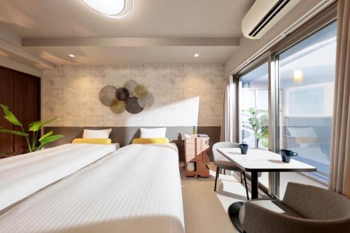 大阪市にある道頓堀クリスタルホテルⅢのベッド2台とテーブルが備わるホテルルームです。
