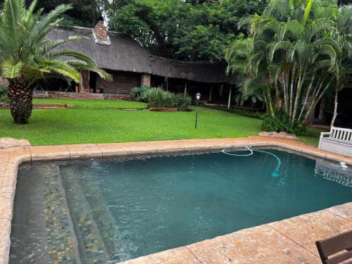 a large swimming pool in a yard with a yard at Khandizwe Kruger Villa in Malelane
