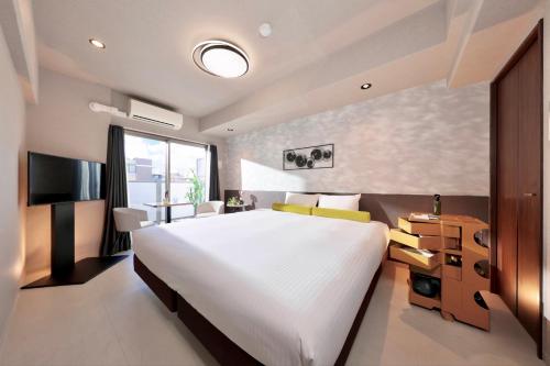 a bedroom with a large bed and a television at Dotombori Crystal Hotel 3 in Osaka