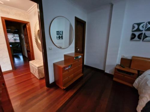 a bedroom with a mirror and a dresser and a bed at Alojamiento Alameda in Redondela