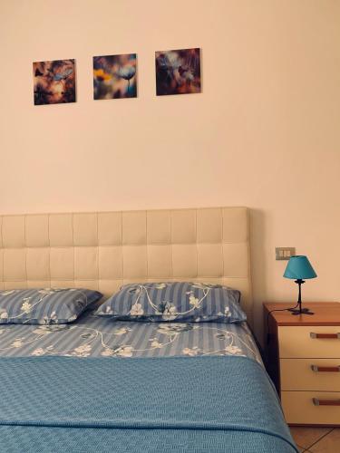 a bedroom with a bed and three pictures on the wall at Dom a Verona in Verona