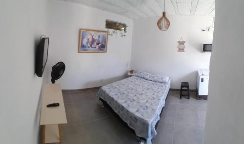 ein Schlafzimmer mit einem Bett und einem TV in der Unterkunft Suíte completa s/ Fogão in São Pedro da Aldeia