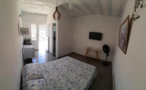 ein Schlafzimmer mit einem Bett in der Mitte eines Zimmers in der Unterkunft Suíte completa s/ Fogão in São Pedro da Aldeia
