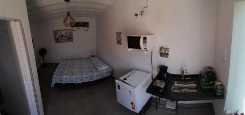 Kleines Zimmer mit einem Bett und einem TV in der Unterkunft Suíte completa s/ Fogão in São Pedro da Aldeia