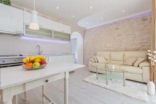 a kitchen and living room with a bowl of fruit on a table at Big Blue Apartments in Dubrovnik
