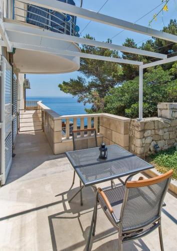 a patio with a table and chairs and the ocean at Big Blue Apartments in Dubrovnik