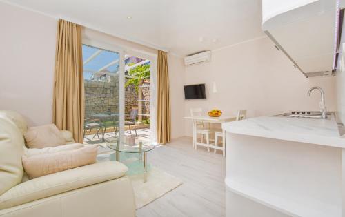 a kitchen and living room with a couch and a table at Big Blue Apartments in Dubrovnik
