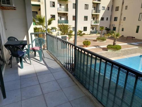 a balcony with a table and chairs next to a swimming pool at Cosy 4 Bedroom Apt with use of Pool in St Paul's Bay