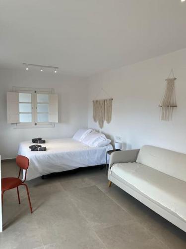 una camera da letto bianca con un letto e un divano di Casa Plaza 2 a Vega de Río de Palmas