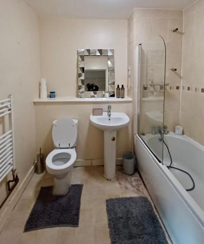 a bathroom with a toilet and a sink and a tub at Alba, 2 Bed Flat, by Grays Station, Free Parking in Stifford