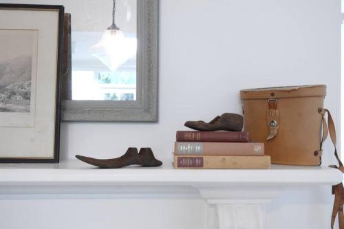 a shelf with a suitcase and books and shoes at The Cobbler in Royal Park