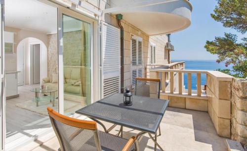 a table and chairs on a balcony with the ocean at Big Blue Apartments in Dubrovnik