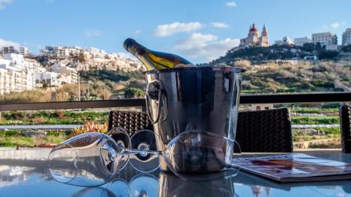 a bottle of wine in a bucket on a table at Mellieha Bay 3 Bedroom Apartment " Bliss on the bay " in Mellieħa